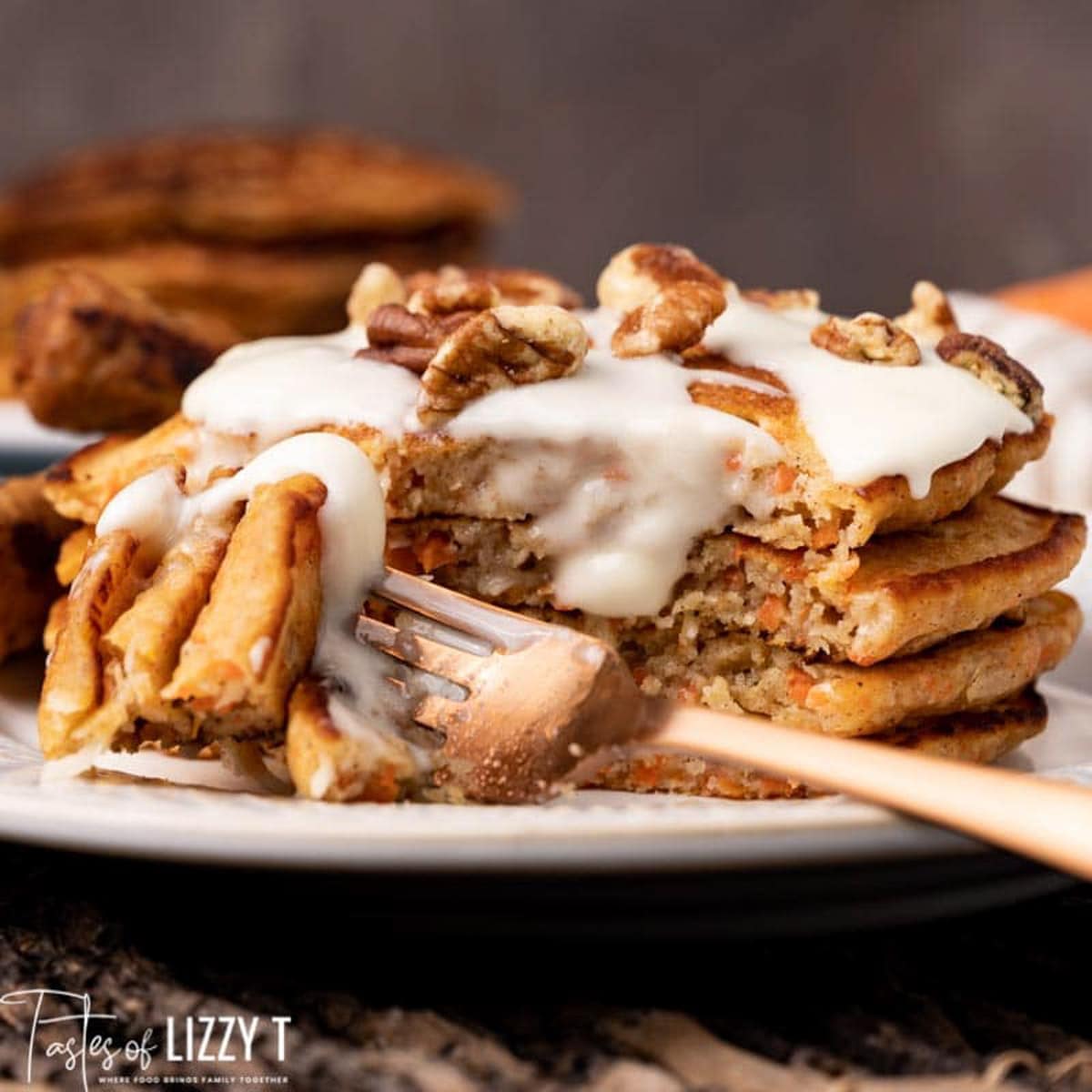 a stack of carrot cake pancakes on a plate with a fork