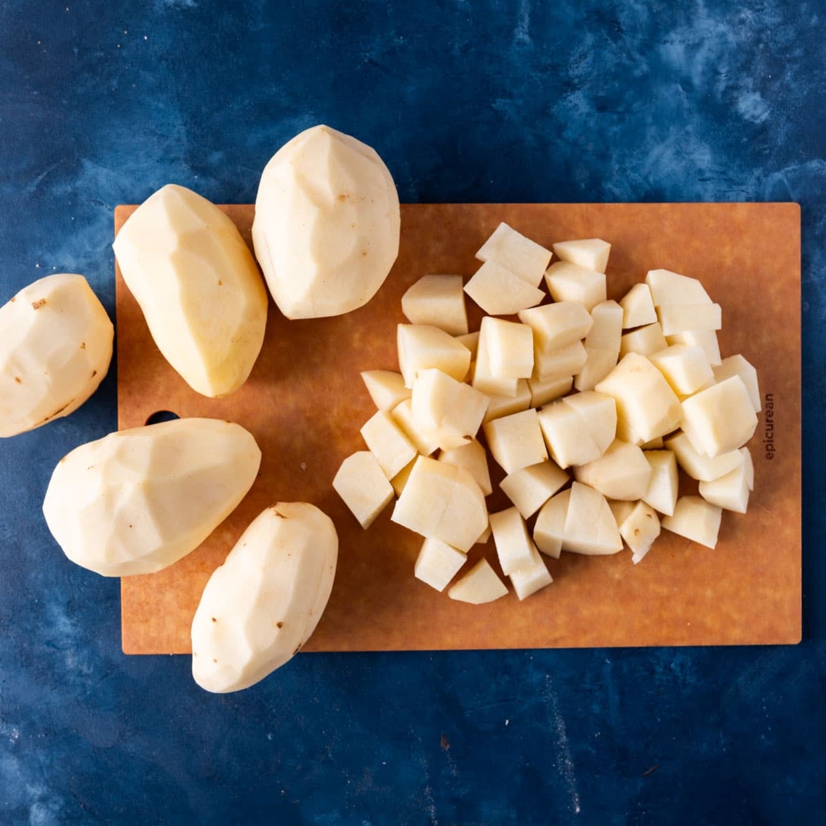 peeled russet potatoes on a cutting board