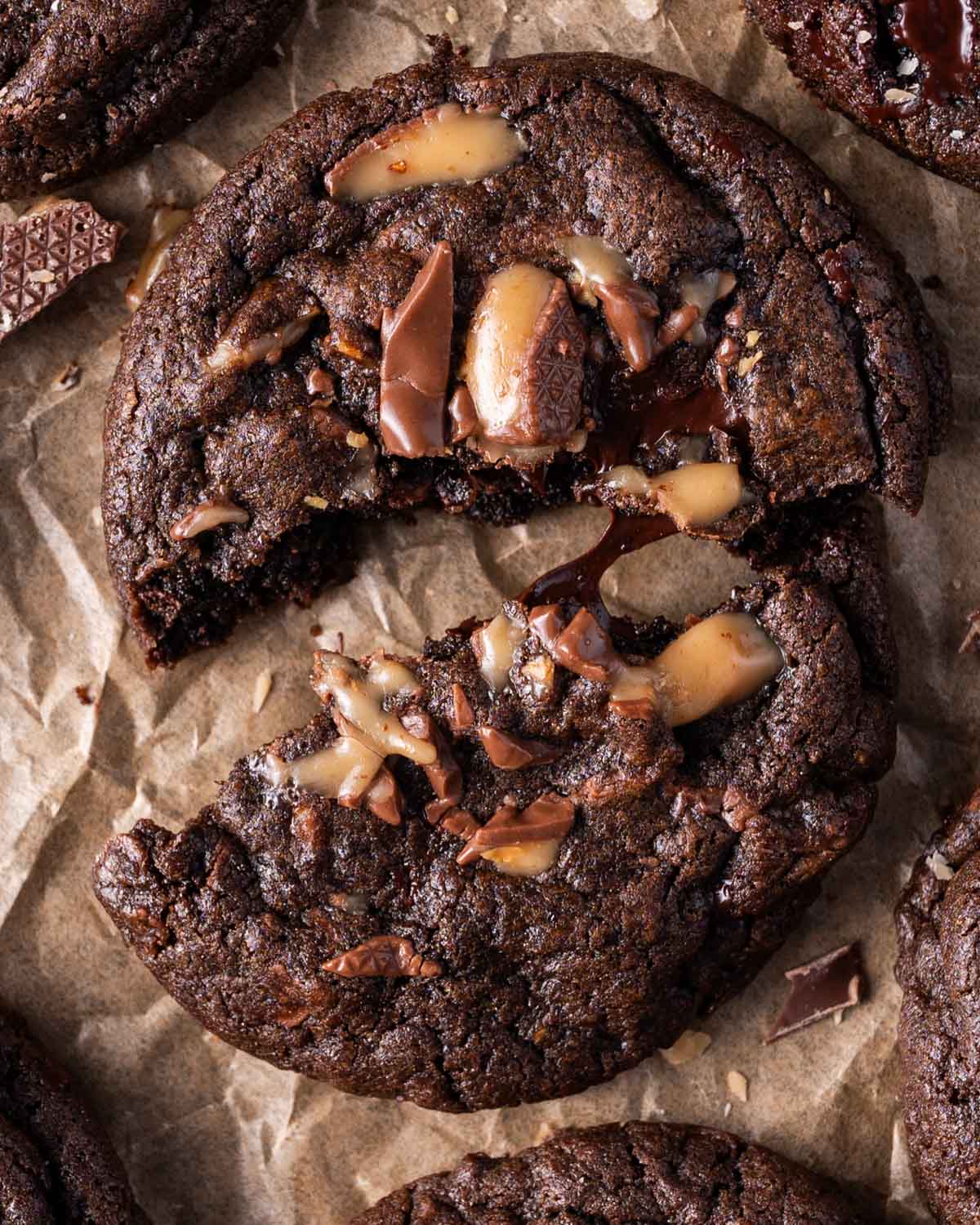 a chocolate cookie with toffee on top broken in half