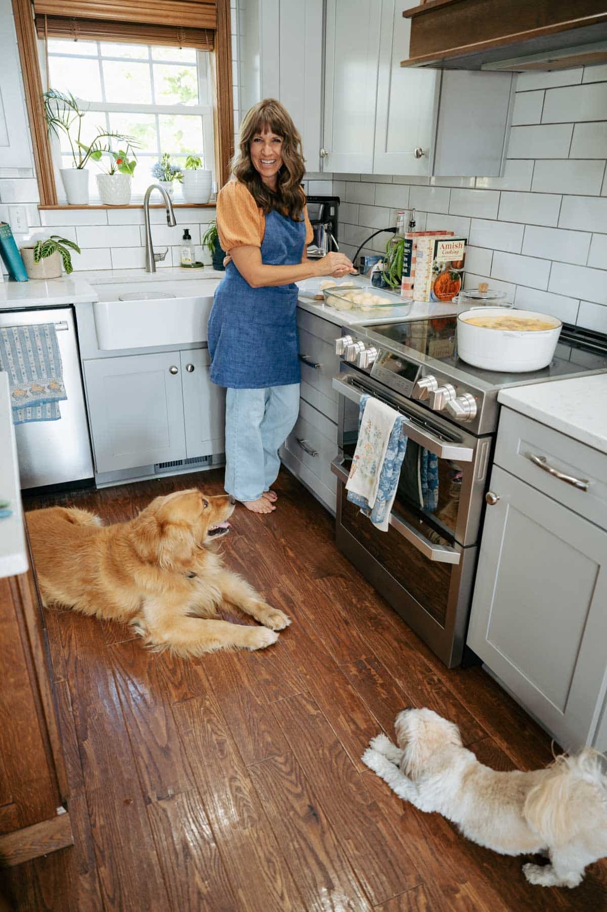 julie clark cooking in her kitchen with her two dogs watching