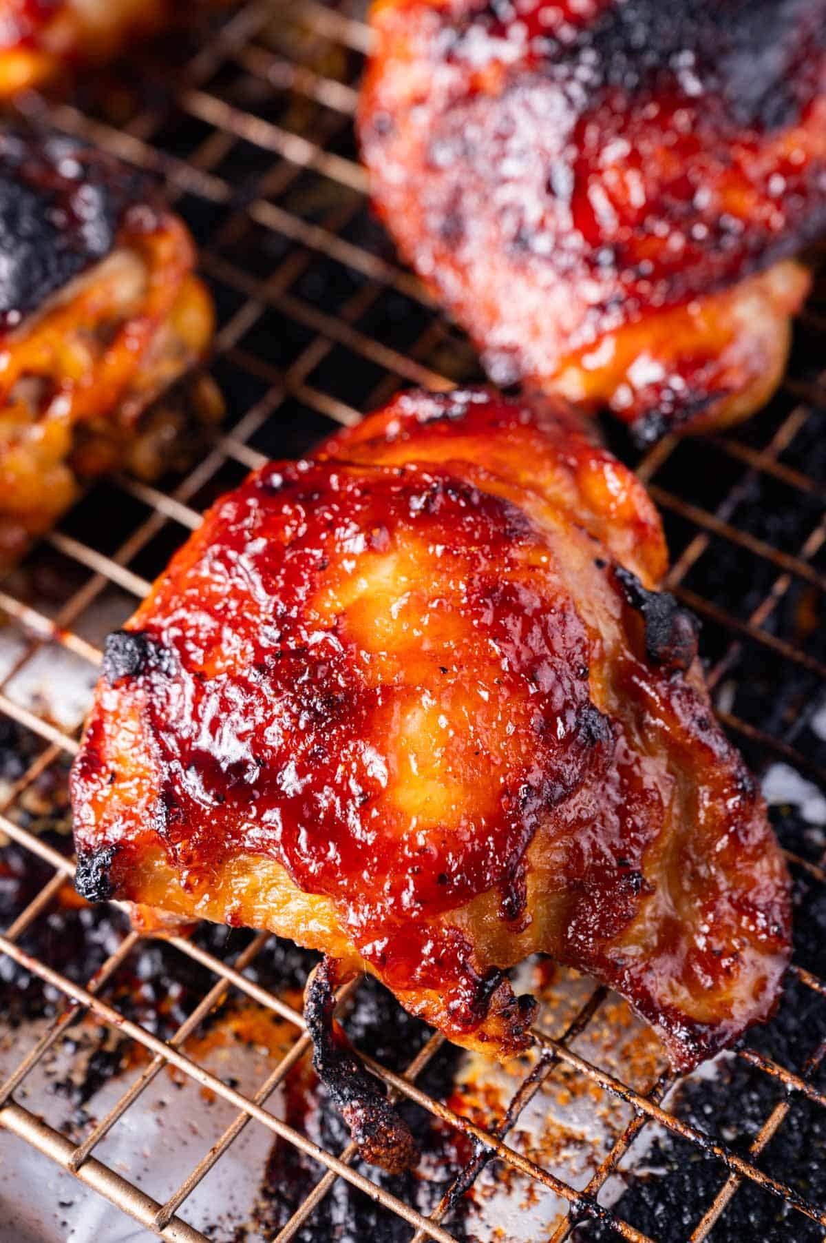 a baked bbq chicken thigh on a baking rack