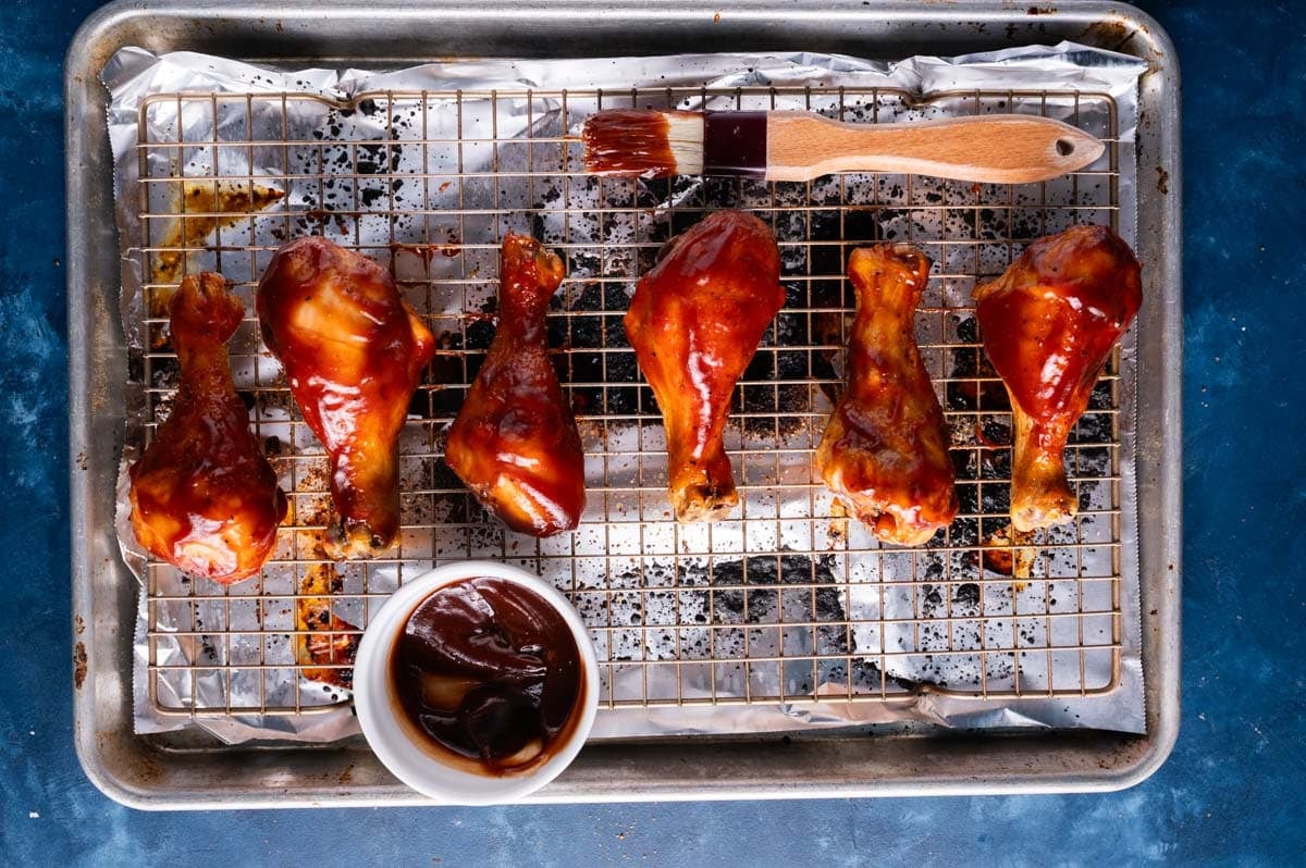 baked chicken legs with bbq sauce brushed on them