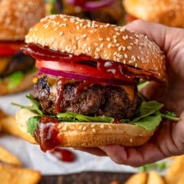 closeup of a bbq bacon burger with sesame seed bun