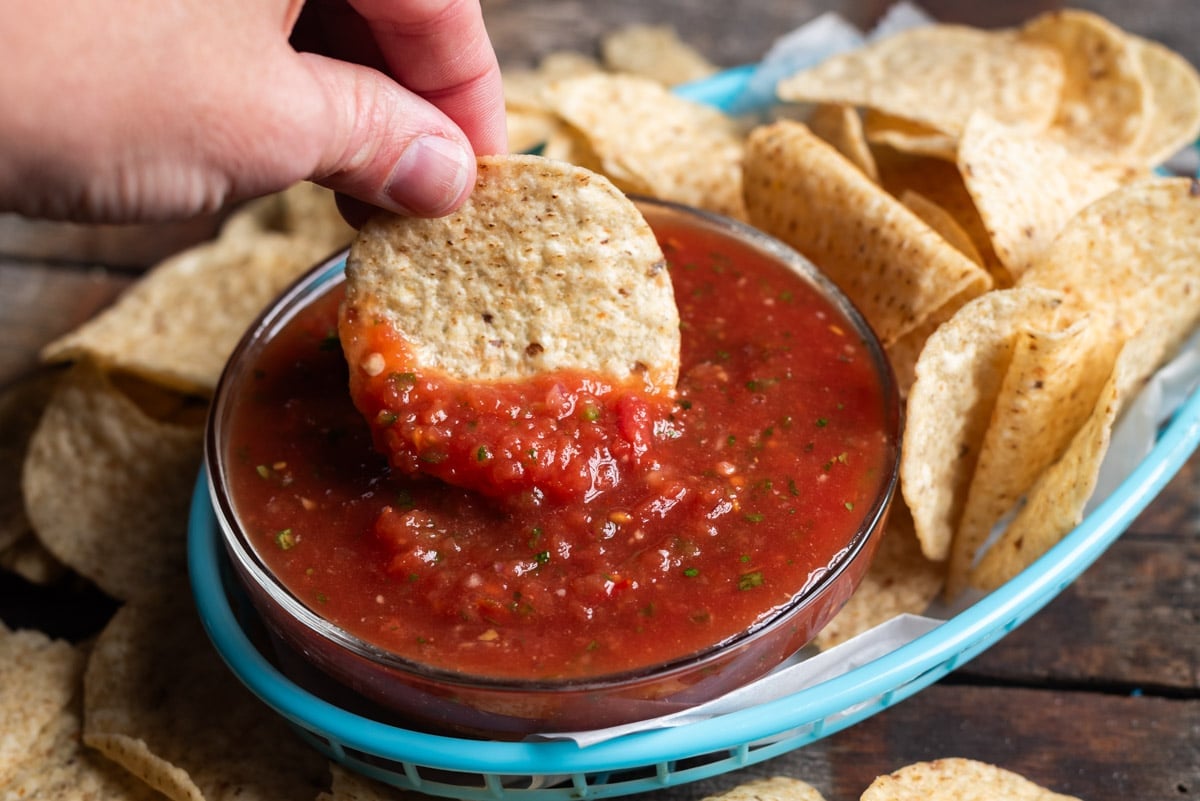 dipping a chip into restaurant style salsa
