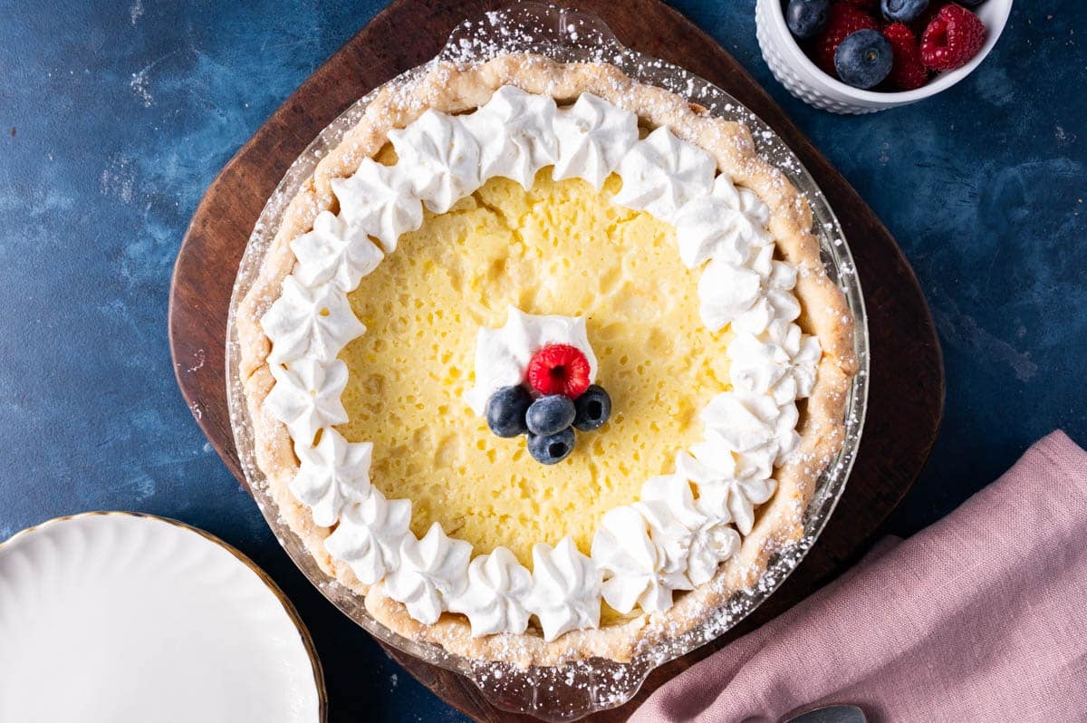 baked buttermilk pie with whipped cream and fresh berries