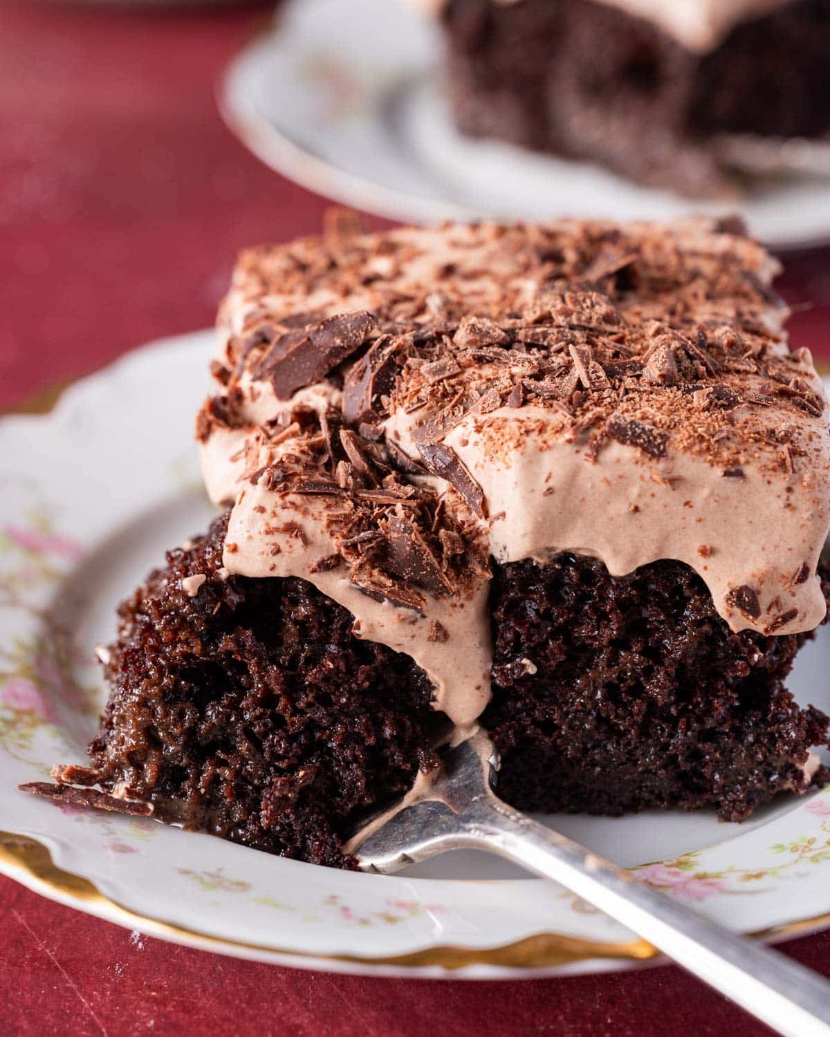 a piece of chocolate tres leches cake on a plate with a fork