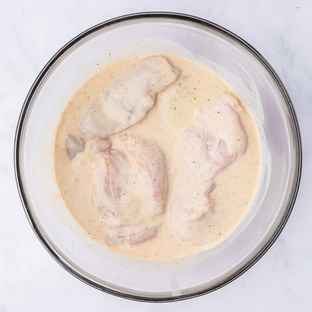 chicken marinating in a bowl