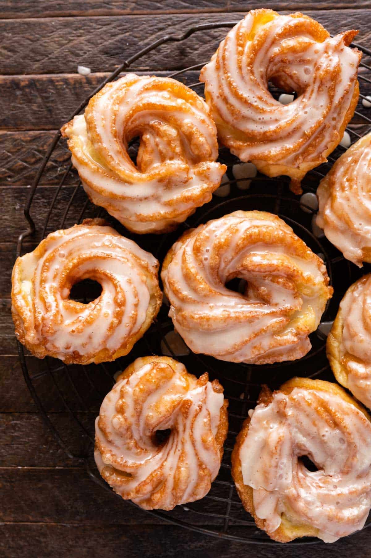 overhead view of glazed cruller donuts on a wire rack