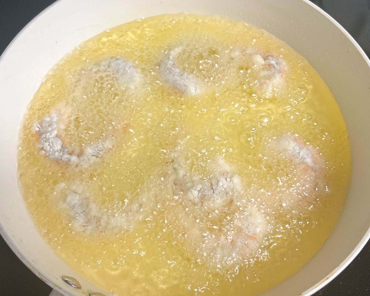shrimp coated in cornstarch frying in oil
