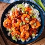 a plate of fried firecracker shrimp on a bed of rice