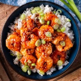 a plate of fried firecracker shrimp on a bed of rice