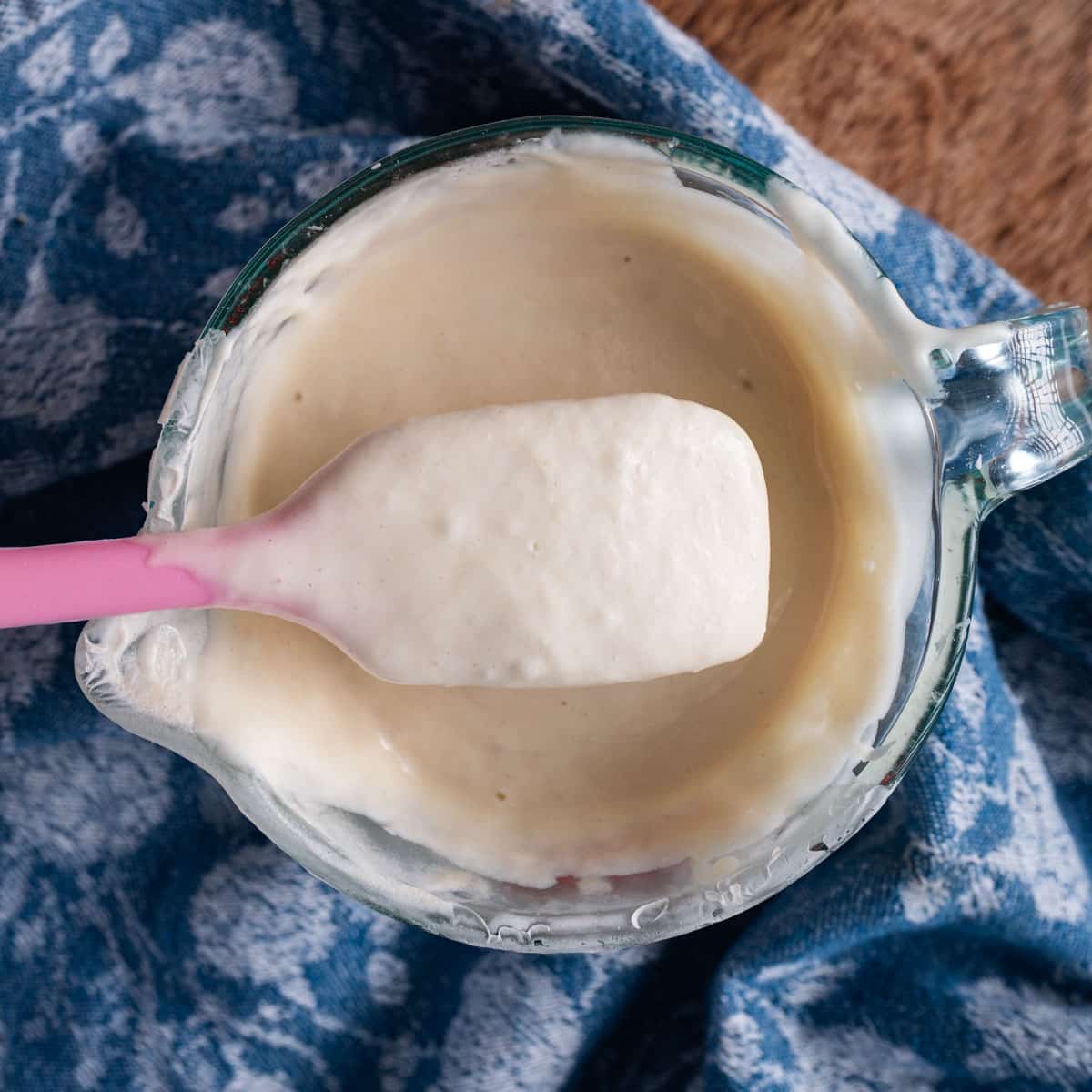 sourdough starter discard in a measuring cup and on a spatula