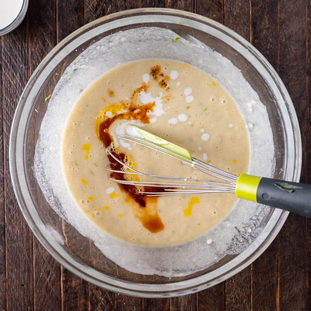 vanilla and milk over lime cake batter in a bowl