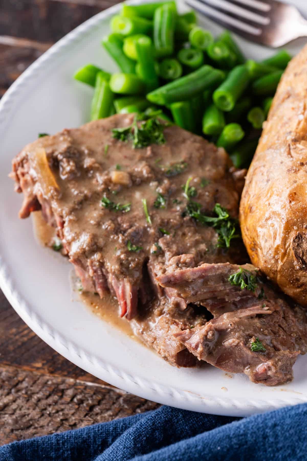 paleo swiss steak on a plate with a potato and green beans