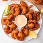 a plate of beer battered shrimp with dipping sauce