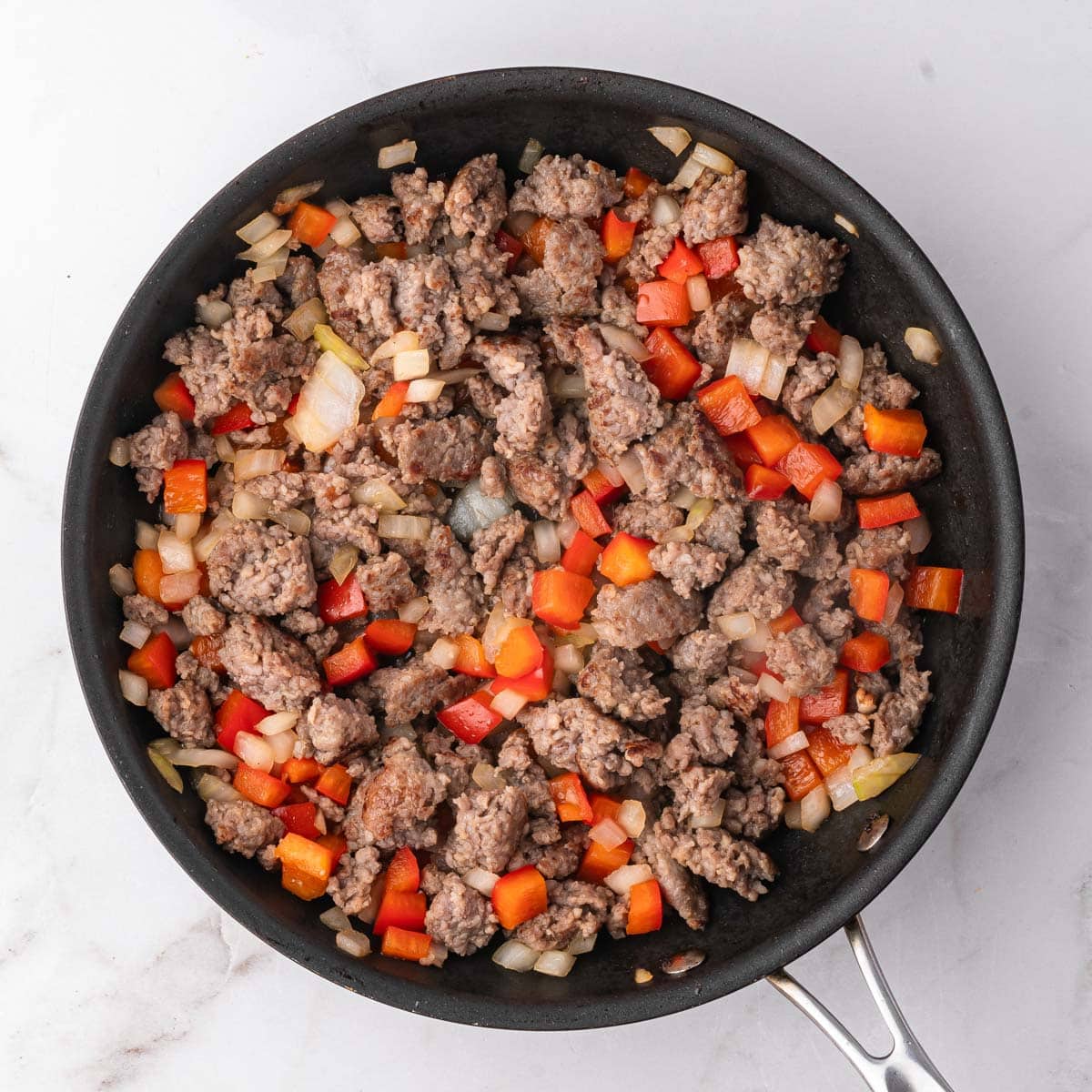 sausage, peppers and onions in a skillet