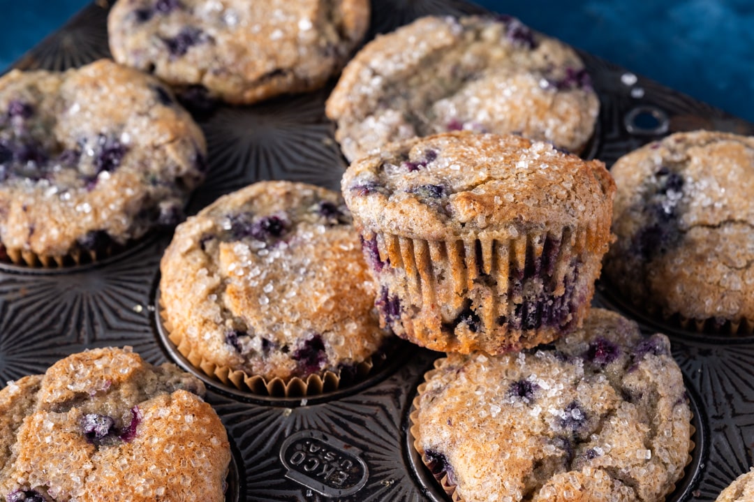 a pile of blueberry muffins with sugar on top