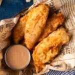 a platter of fried chicken tenders with dipping sauce