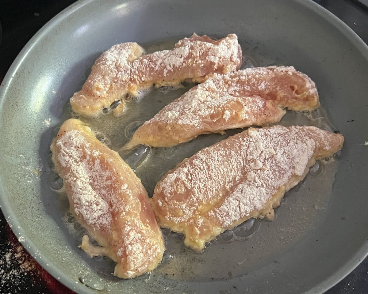 breaded chicken frying in a skillet