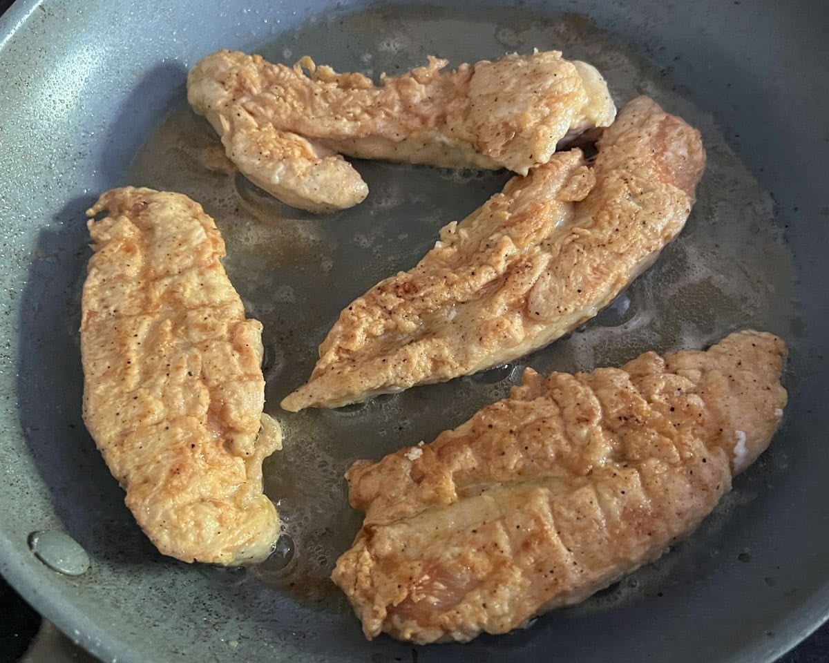 chicken frying in a skillet