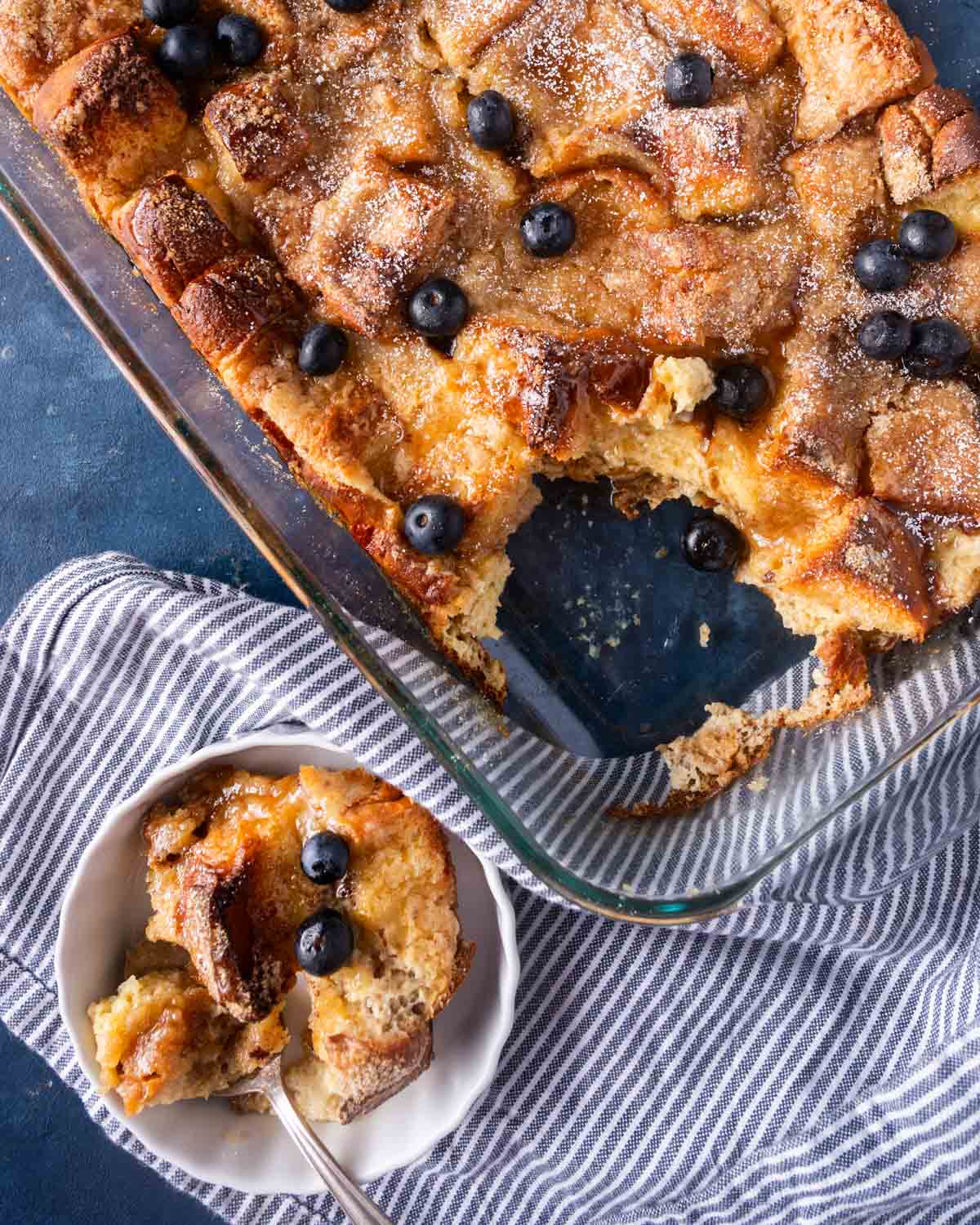 overhead view of french toast casserole with blueberries on top on a table