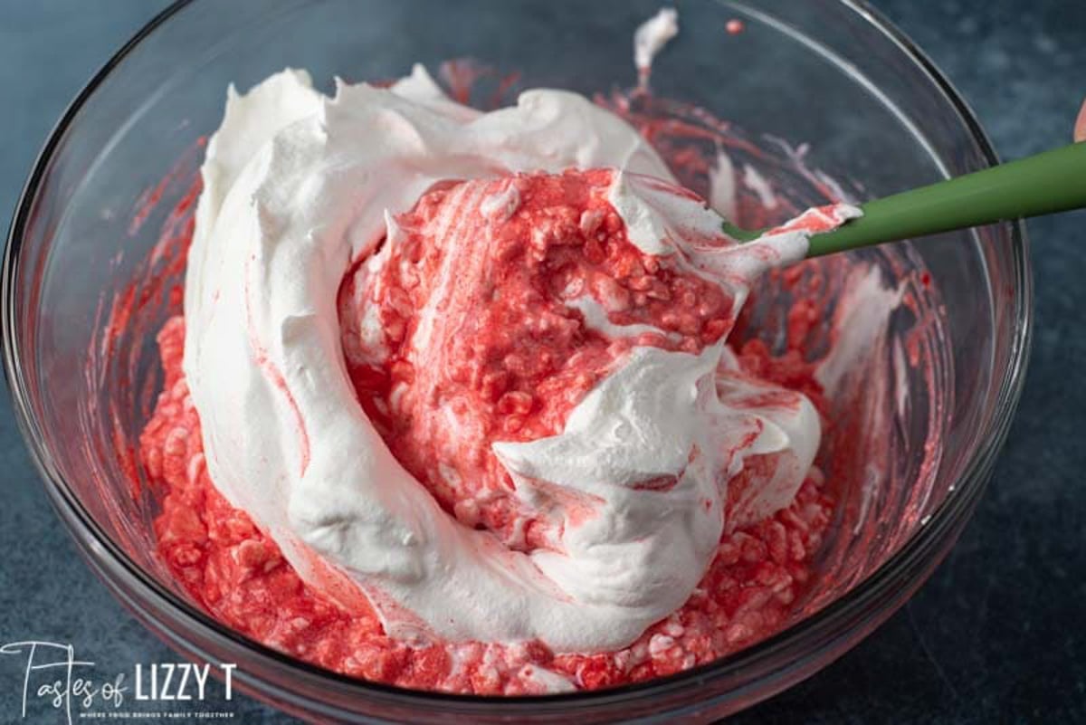 jello powder folding into cool whip in a bowl