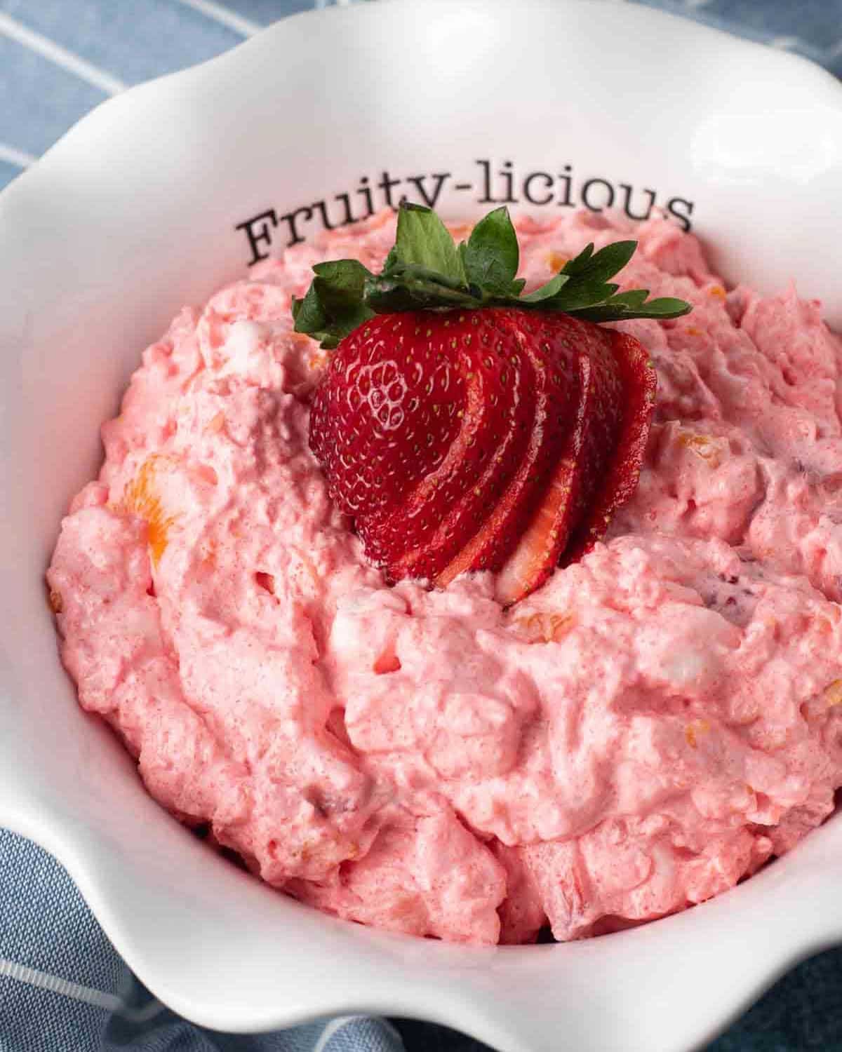 jello fluff salad with sliced strawberries on top in a bowl
