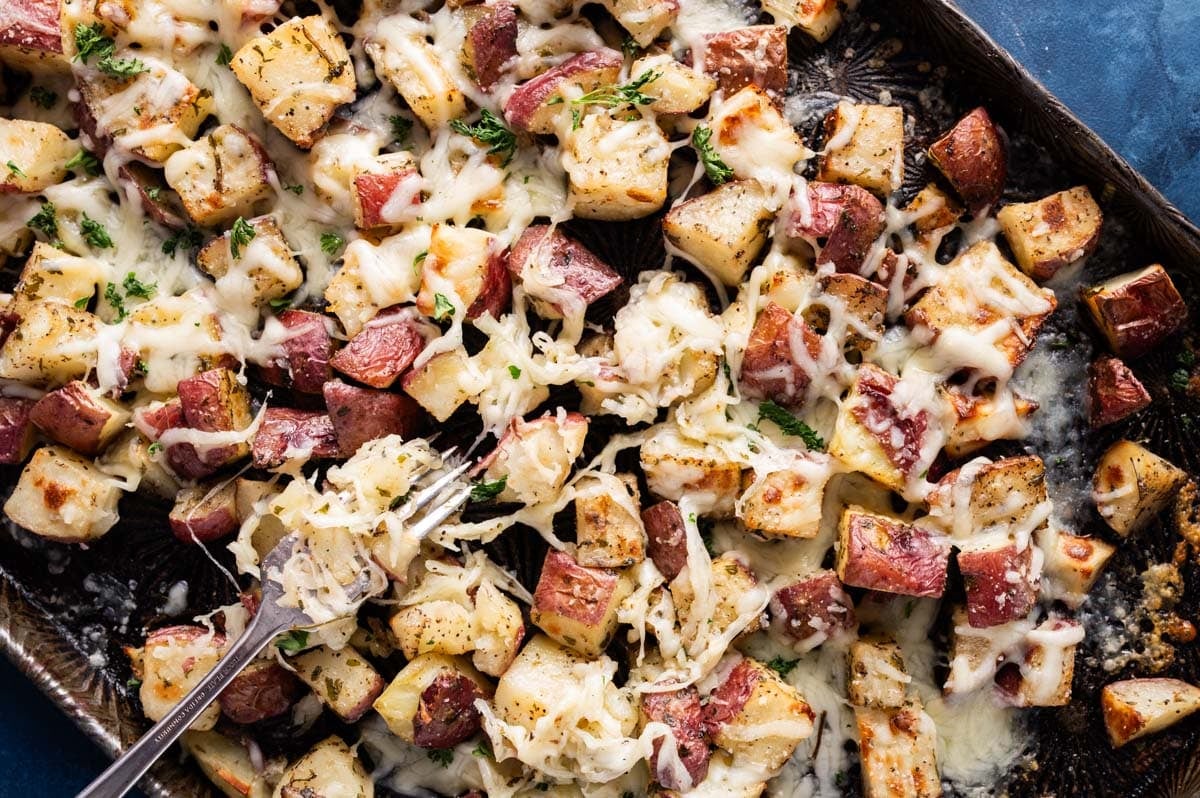 overhead view of oven roasted cheesy potatoes on a pan