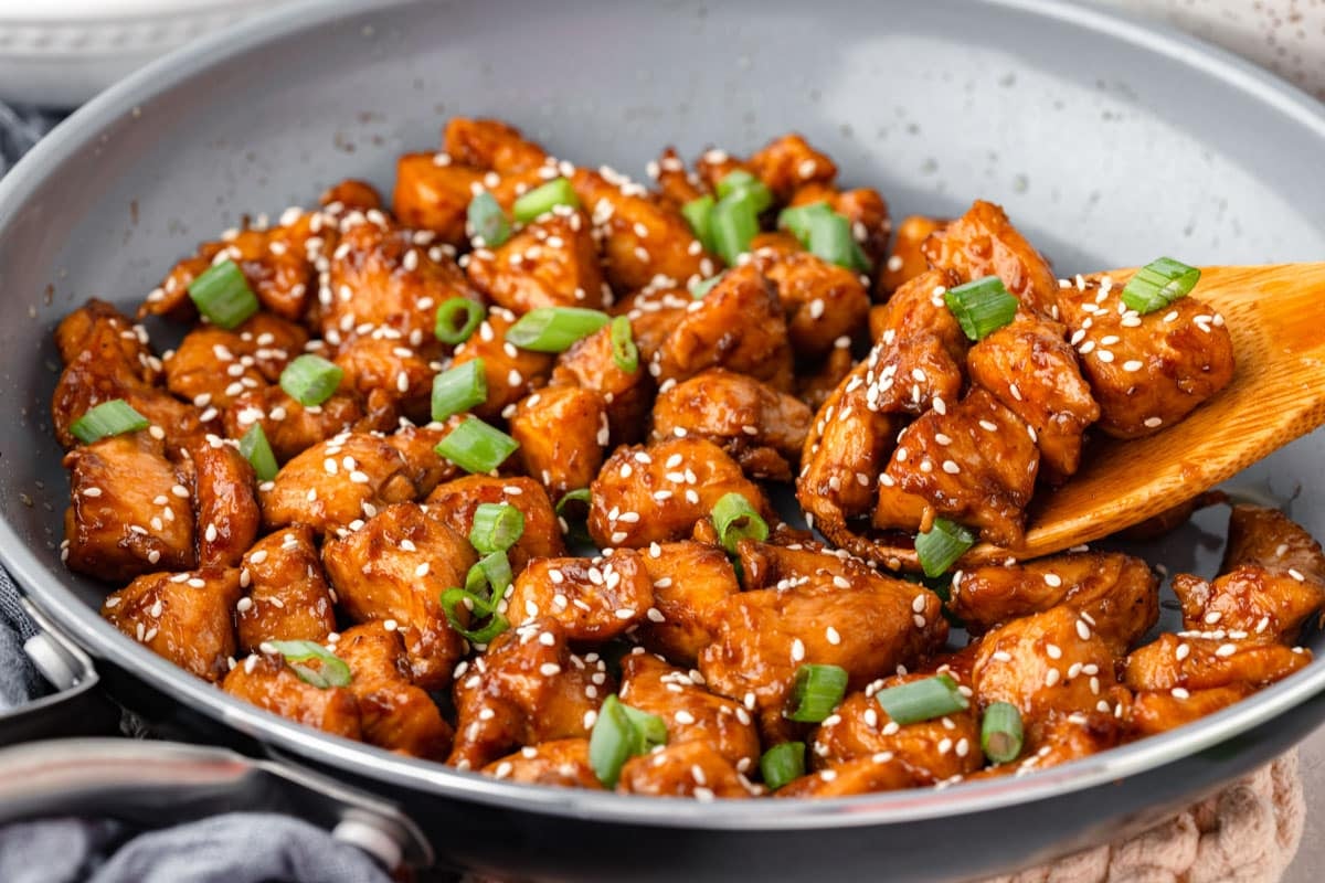 hoisin chicken in a skillet with green onions on top