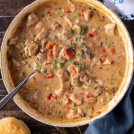 creamy chicken a la king in a skillet with a spoon