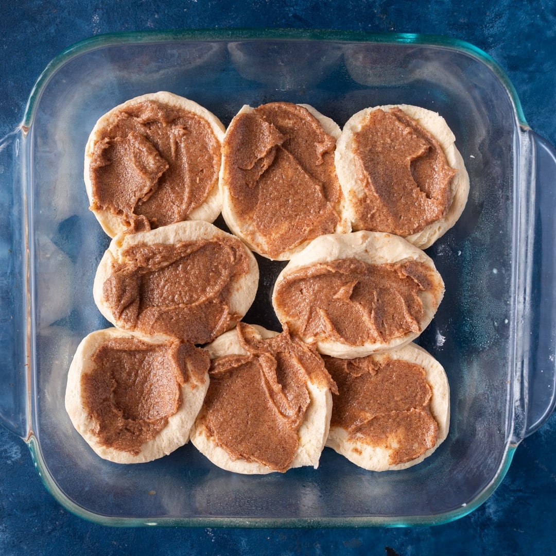 unbaked biscuits with cinnamon butter in a pan
