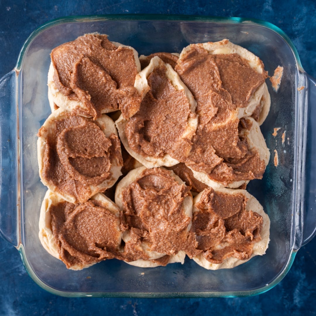 unbaked biscuits with cinnamon butter in a pan