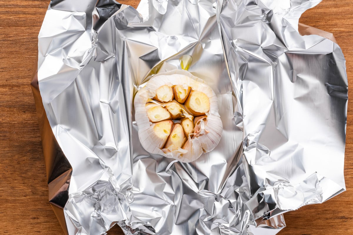 a head of garlic on a piece of aluminum foil