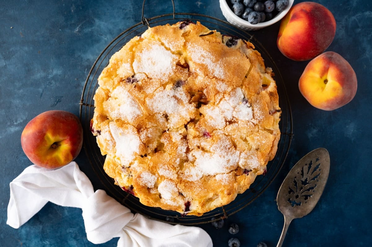 coffee cake with peaches and blueberries on a table