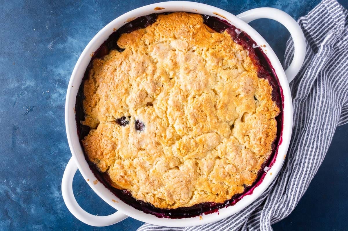 overhead view of a baked cobbler with peaches and blueberries