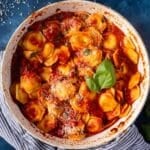 ravioli al pomodoro in a skillet with cheese and basil