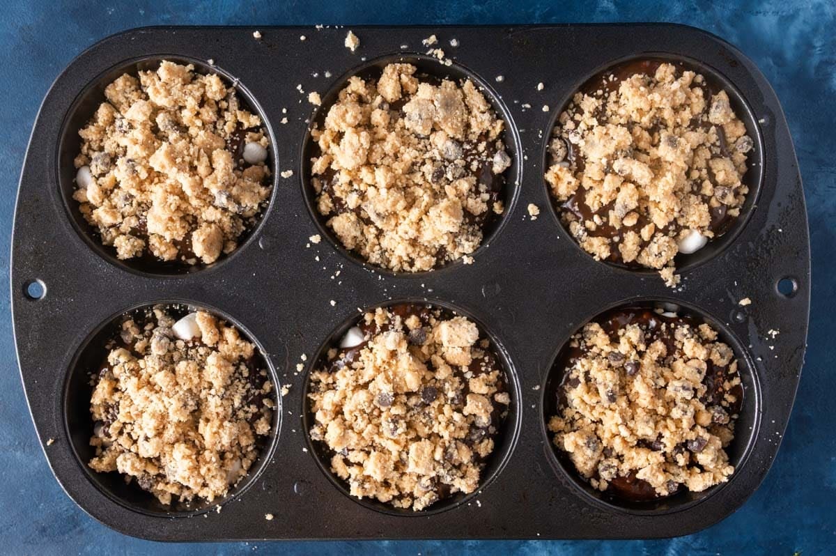 overhead view of unbaked zucchini muffins with crumble on top