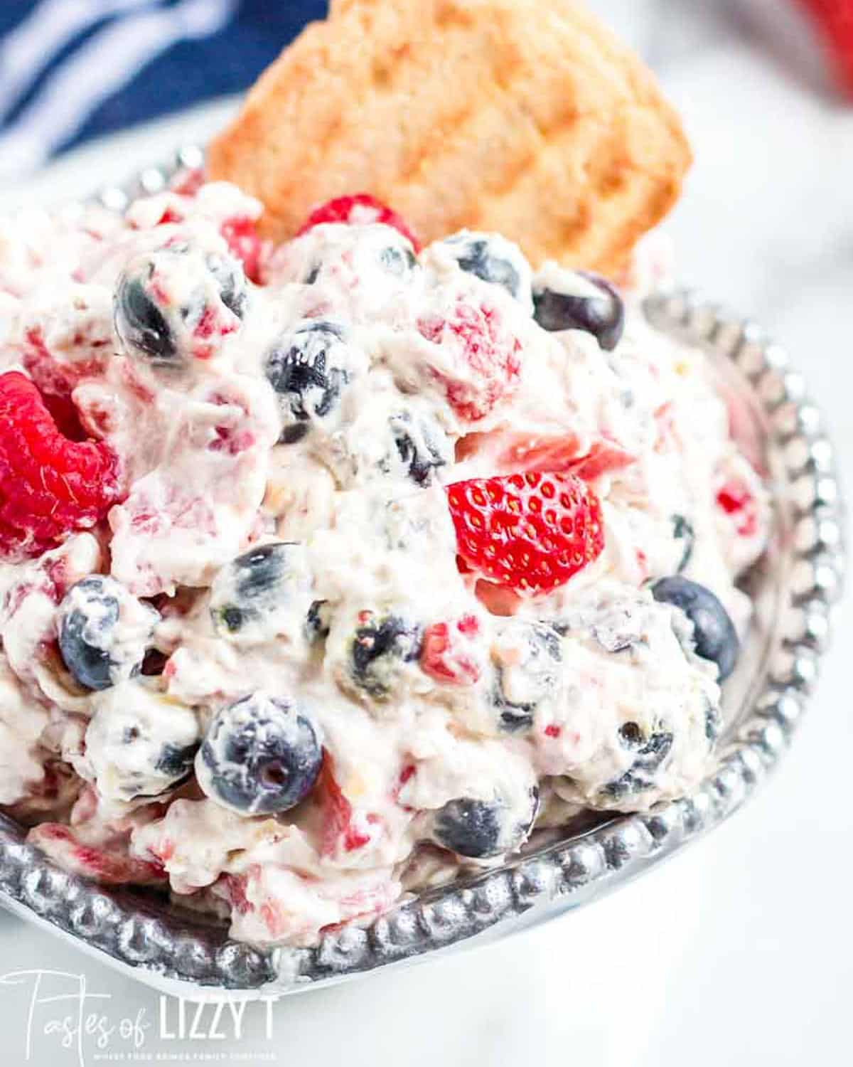 triple berry fruit dip with a cookie in a bowl