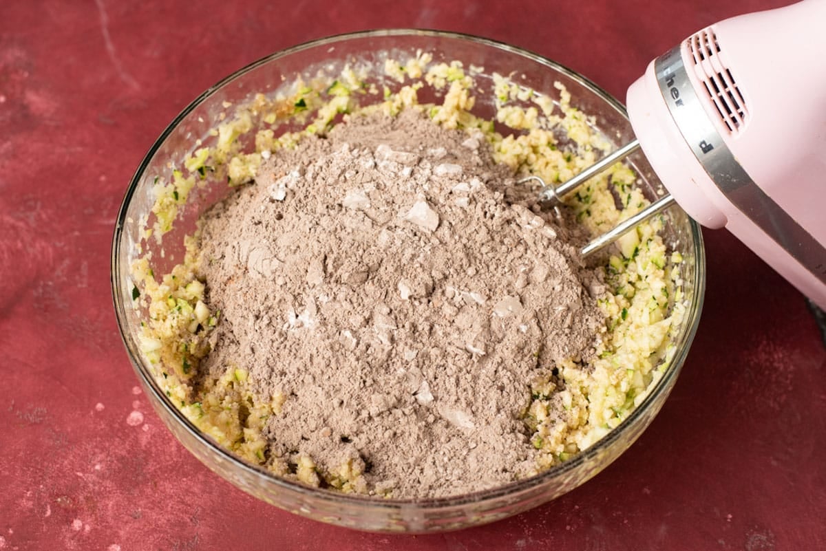 dry ingredients over zucchini mixture in a bowl