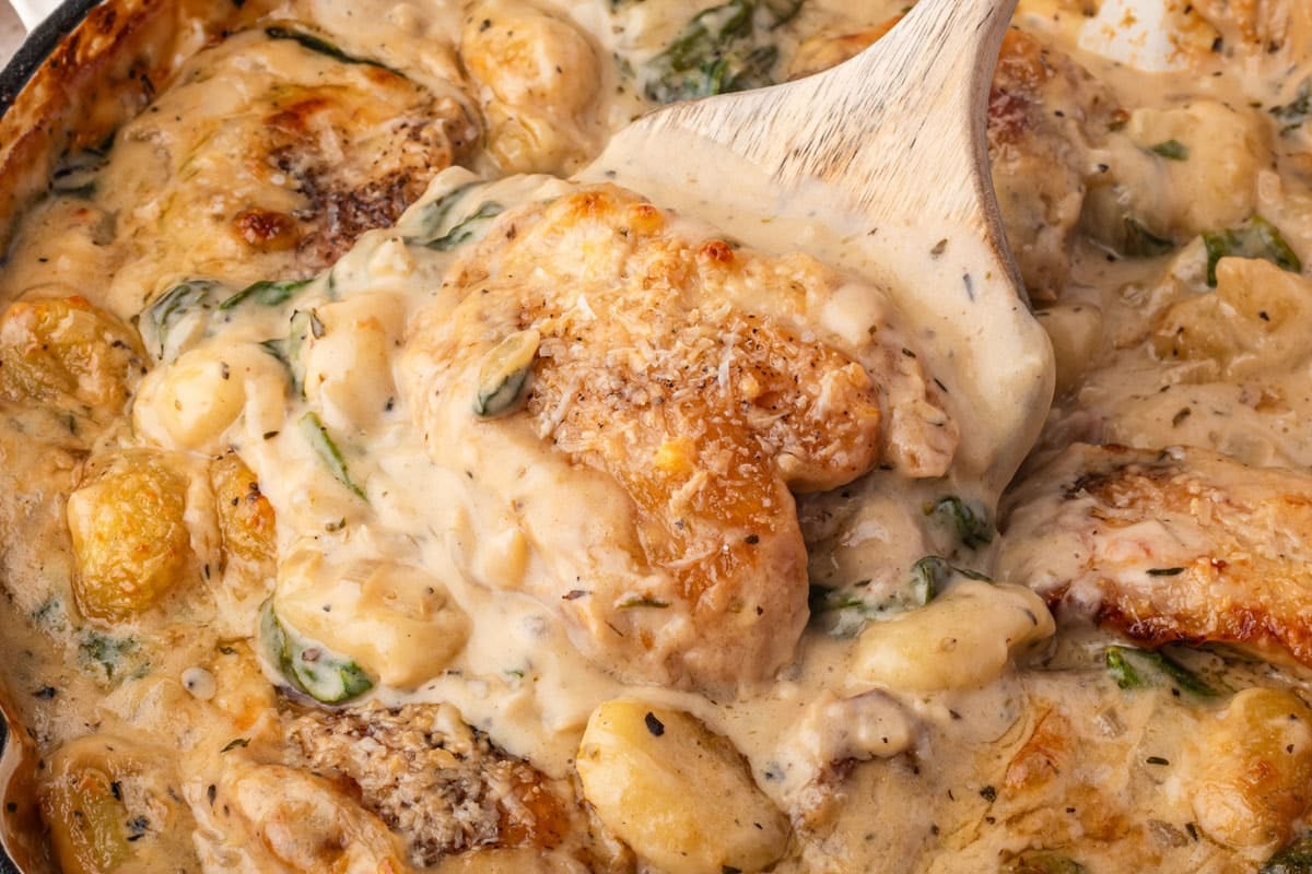 close up of creamy chicken & gnocchi on a wooden spatula