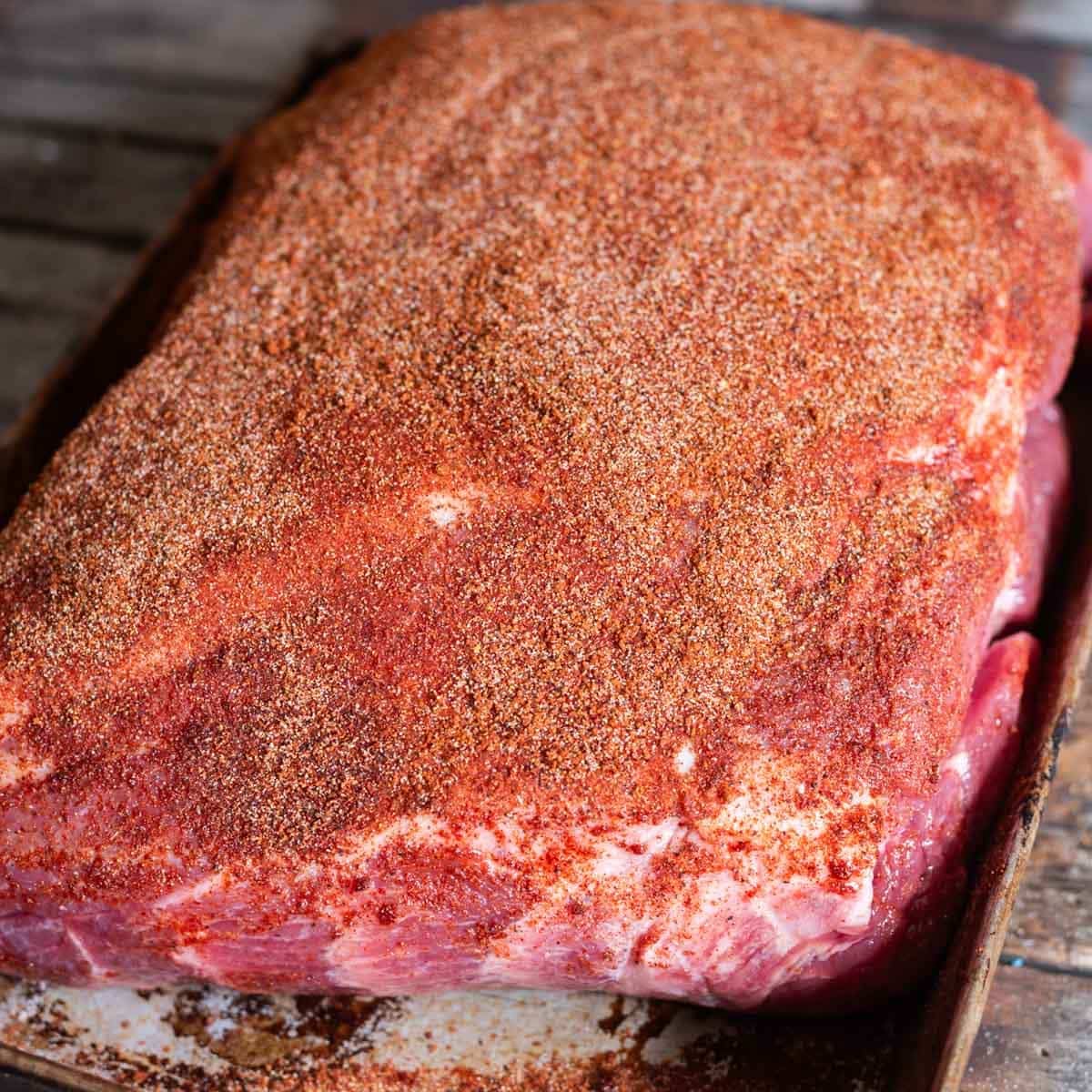 uncooked pork butt with seasoning