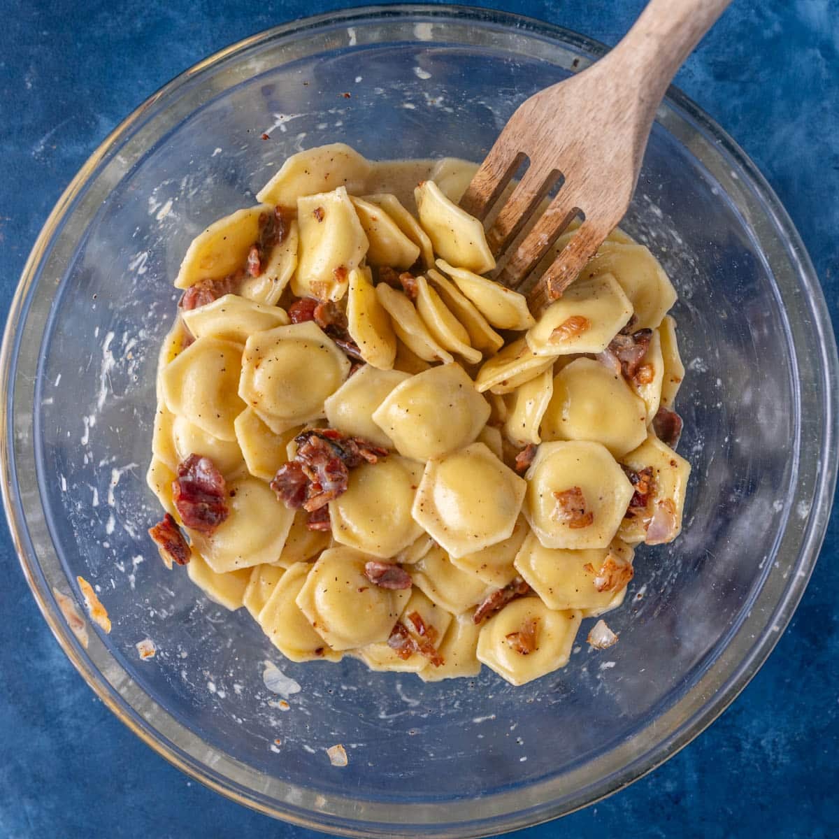 ravioli mixed with carbonara sauce in a bowl