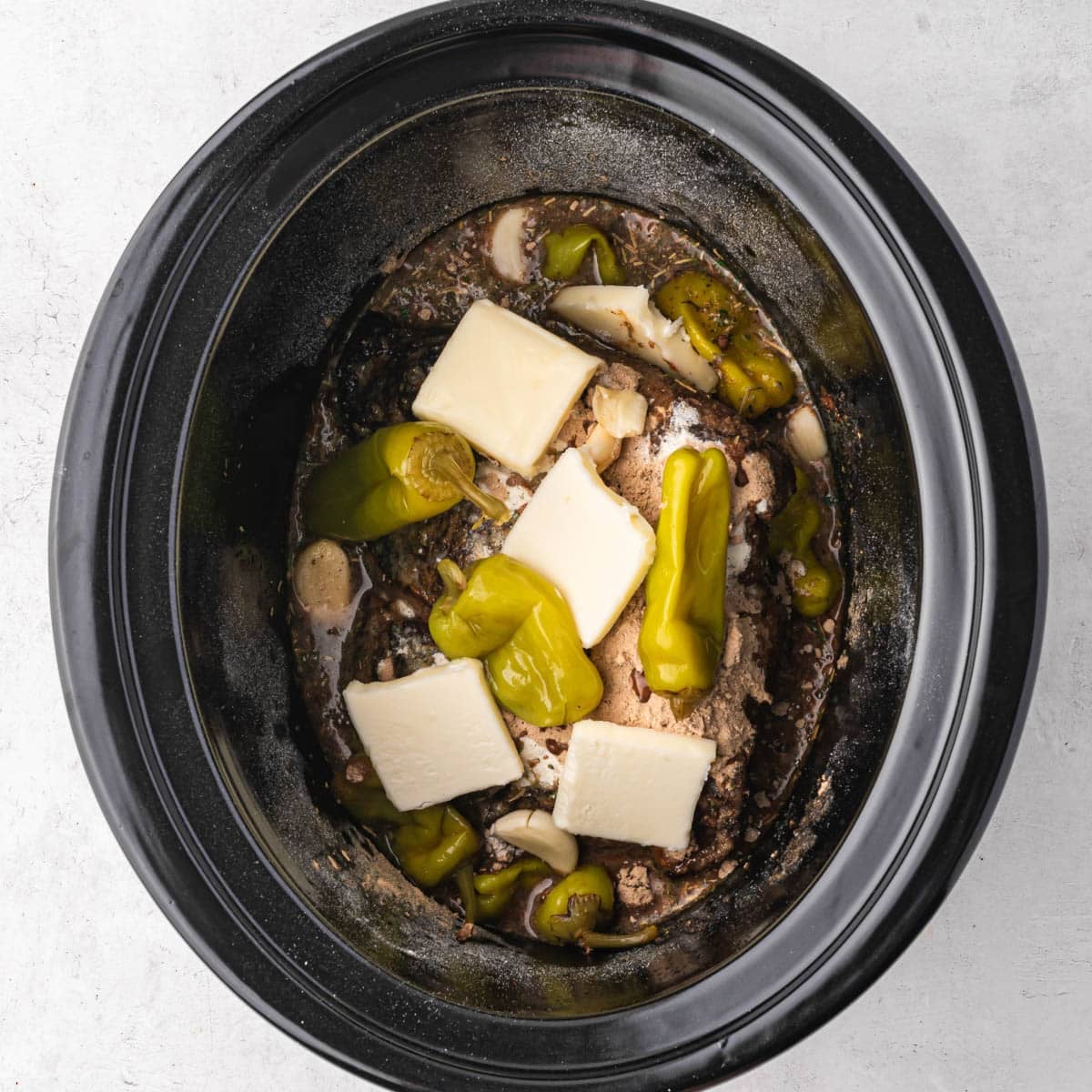 ingredients for pot roast in a slow cooker