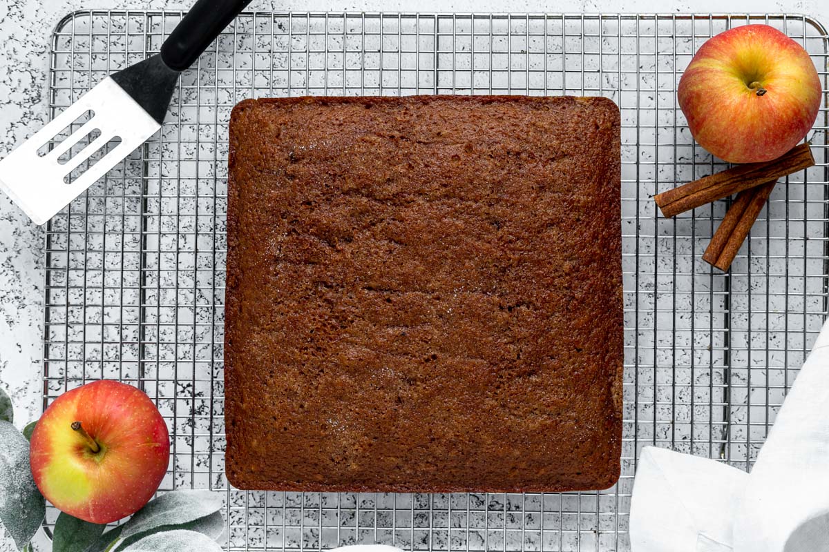 overhead view of a square apple cake on a wire rack