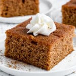 a piece of apple cake on a plate with whipped cream