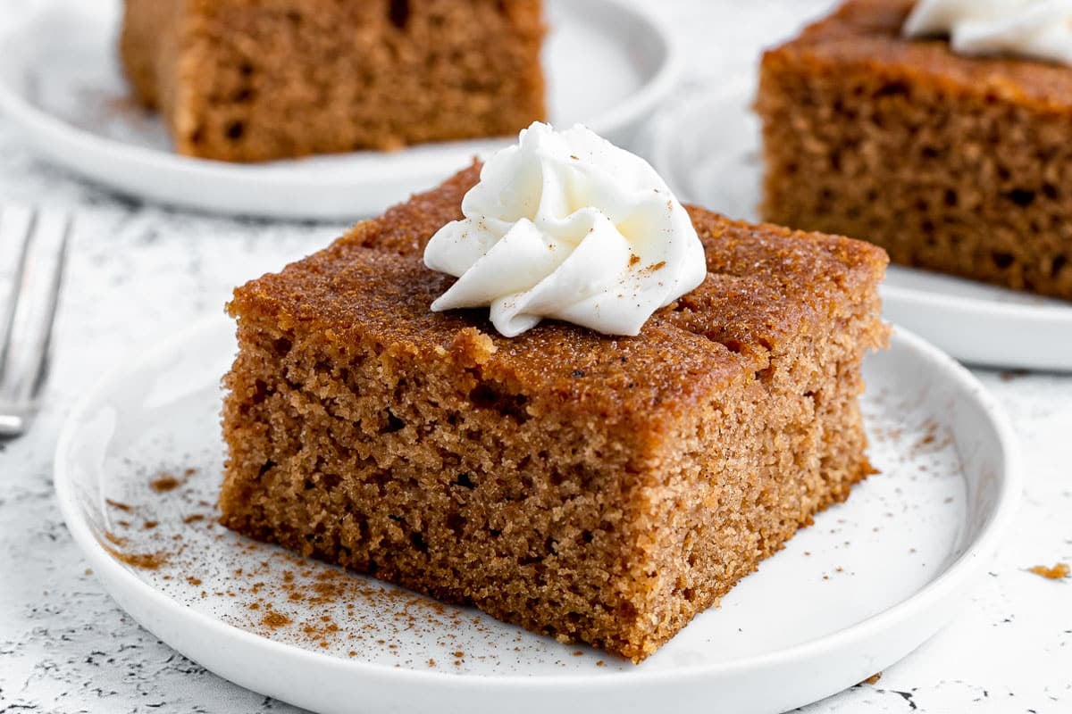 a piece of apple cake on a plate with whipped cream
