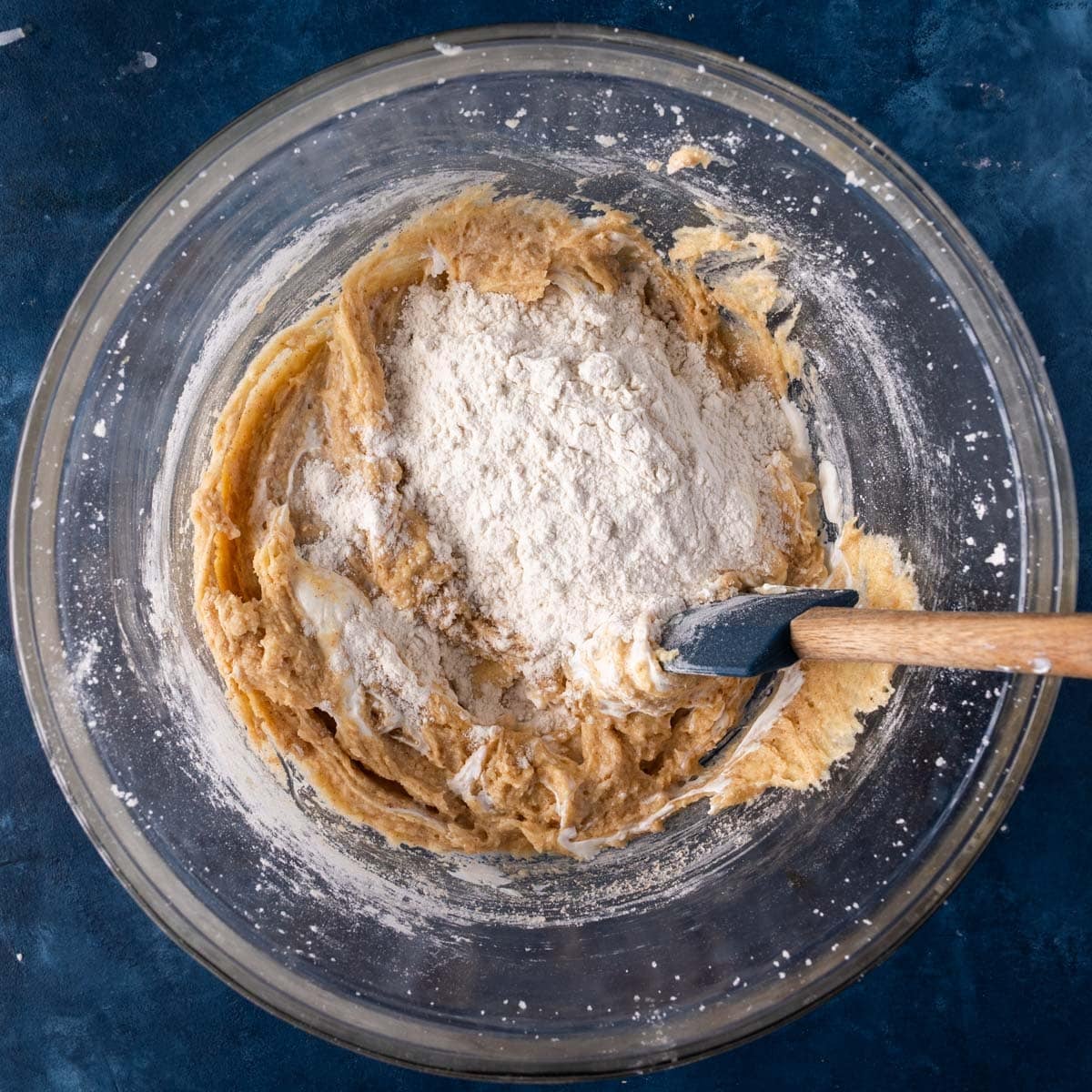 flour over creamed butter and sugar in a bowl