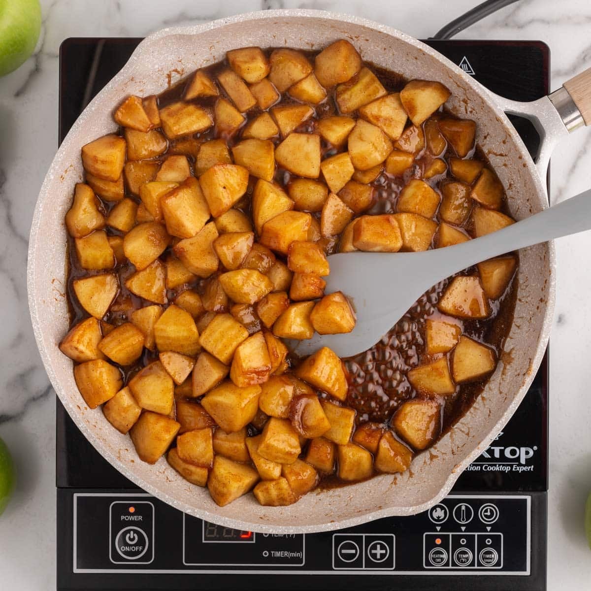 cinnamon sugar diced apples in a frying pan