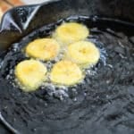 sliced plantains frying in oil