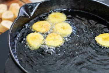 sliced plantains frying in oil
